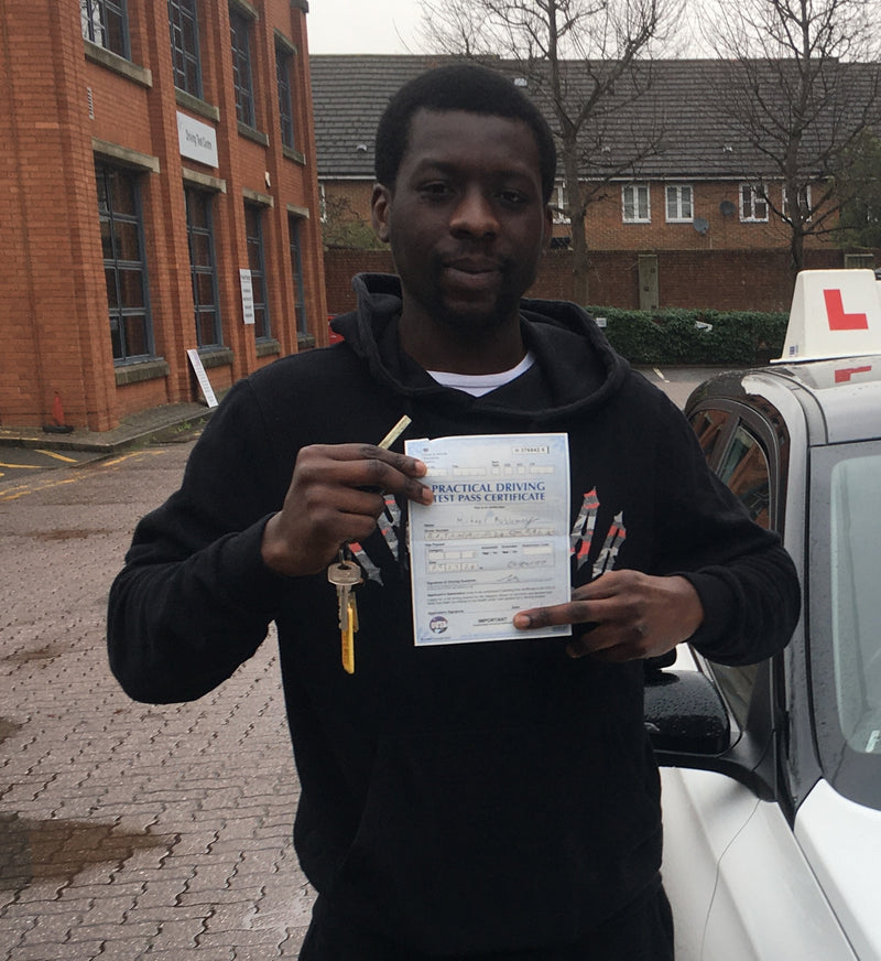 Person holding a driving test certificate and keys in front of a car